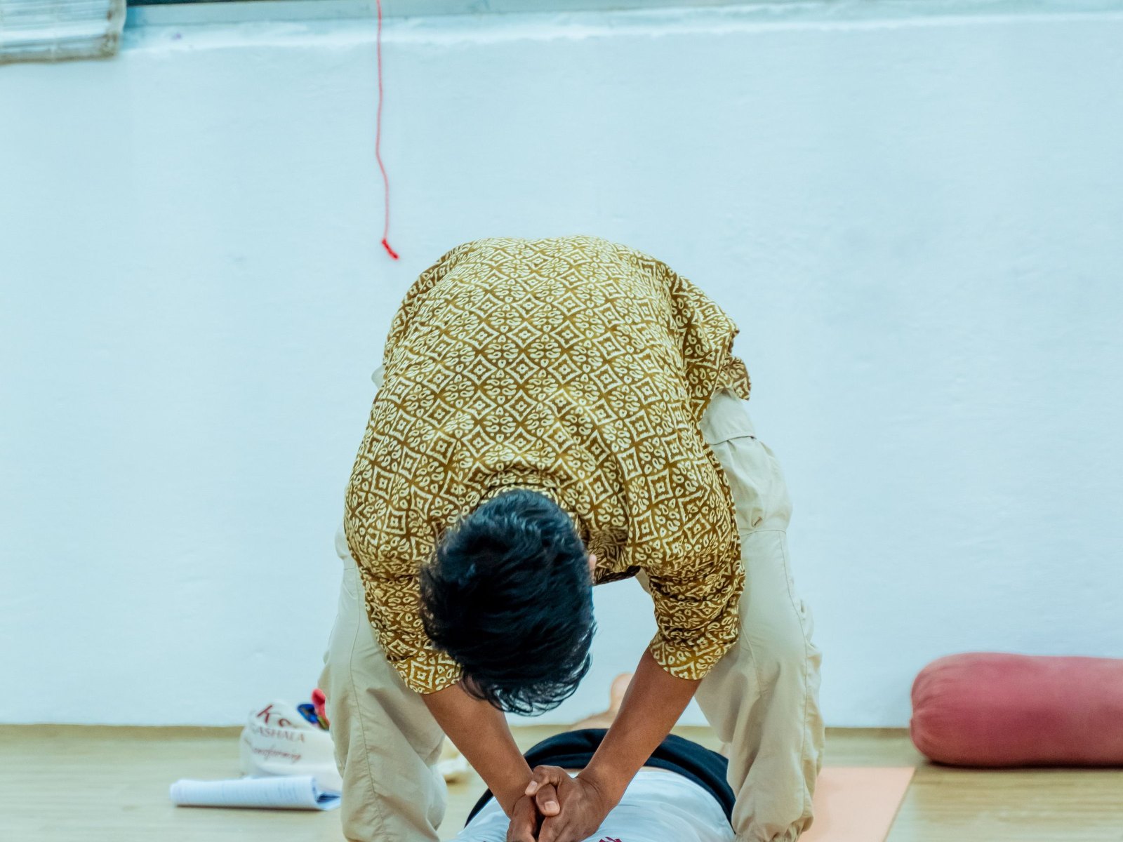 Hands-on postural correction during a private yoga therapy session